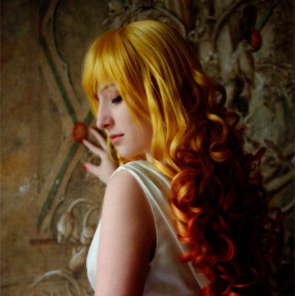 A woman in a white sleeveless dress with long, wavy golden-blonde hair, shown in profile against an ornate brown wall. The image appears heavily edited or AI-generated, with smooth skin, stylized lighting, and a blurred face.