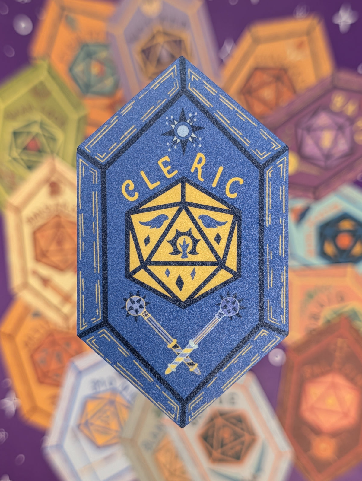 A blue hexagonal sticker featuring the text 'Cleric' above a yellow 20-sided die icon, with crossed silver and gold swords below, set against a blurred purple background with overlapping multicolored geometric shapes.